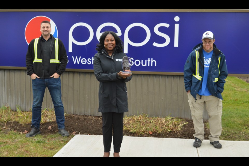 Empower Simcoe CEO Claudine Cousins presents her agency’s Gift of the Heart Community Partner of the Year Award to Pepsico’s Christian Puchalski, left, and Adam Kane. Photo provided by Empower Simcoe