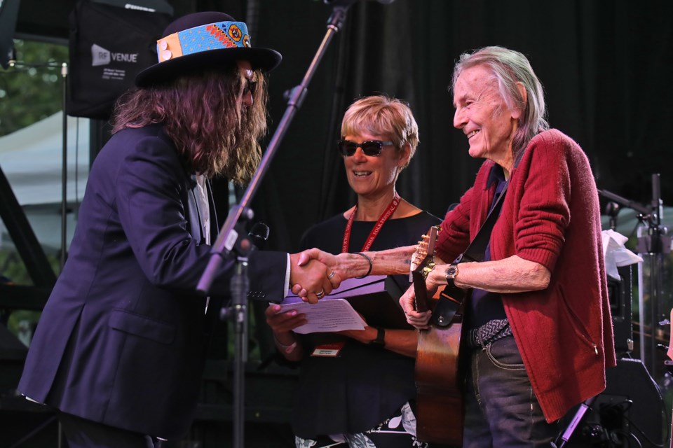 Gordon Lightfoot thanks fellow musician Tom Wilson as he is inducted into the Mariposa Folk Festival hall of fame at the 2022 festival. Between the two is Pam Carter, president of the festival, who will be part of a working group being formed to help establish a Gordon Lightfoot Museum in Orillia.