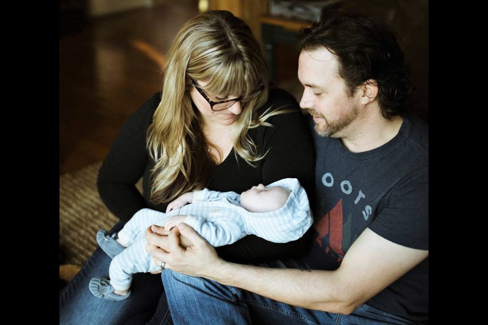 Sarah-Valiquette Thompson and husband, Ian Thompson, share a special moment with their infant son, Harvey. The local family will be marking World Down Syndrome Day today by wearing crazy socks and celebrating the uniqueness of their son. (Joanna Chrichton  Photography)