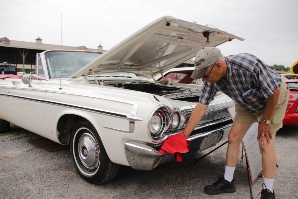 Doug Renault shines up his 1964 Dodge Polara Convertible. Mehreen Shahid/OrilliaMatters