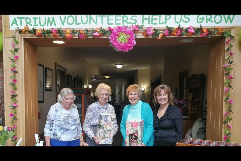 From left: Volunteer Resident Ambassadors: Nancy Callum, Delores Beard and Joyce Rostance
receive flowers from Lana May, Life Enrichment Manager of the Atrium.