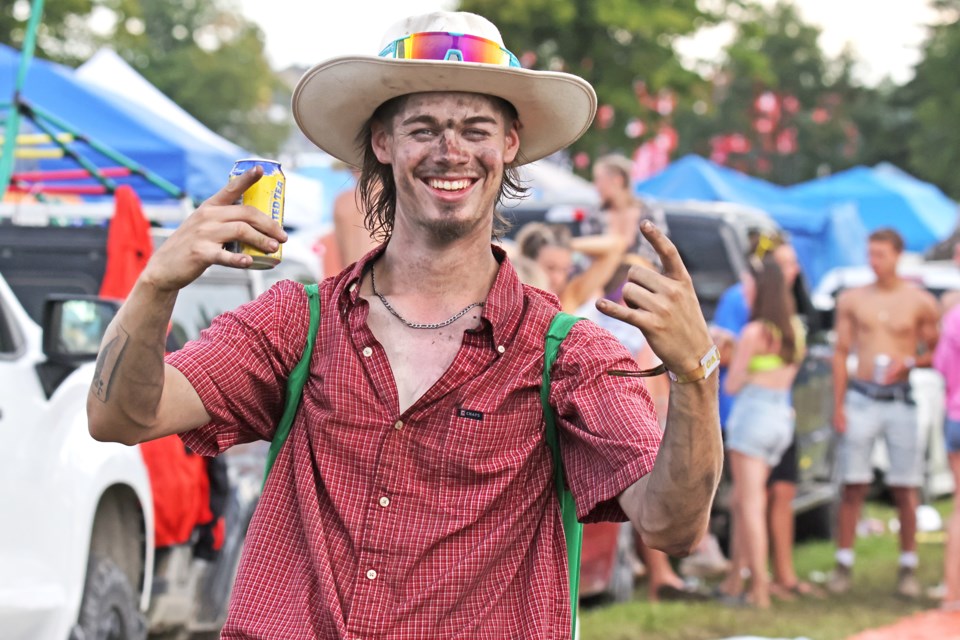 A little rain and mud is no prblem for this fan inside the campground at the Boots and Hearts Music Festival on Saturday night at Burl's Creek Event Grounds in Oro-Medonte. 