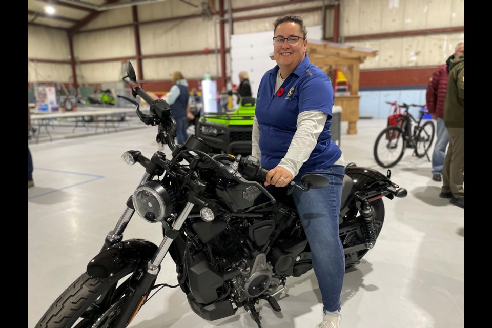 Stephanie Pegelo shows off the Harley-Davidson motorcycle that was up for grabs during the  Kiwanis Auction on Saturday.