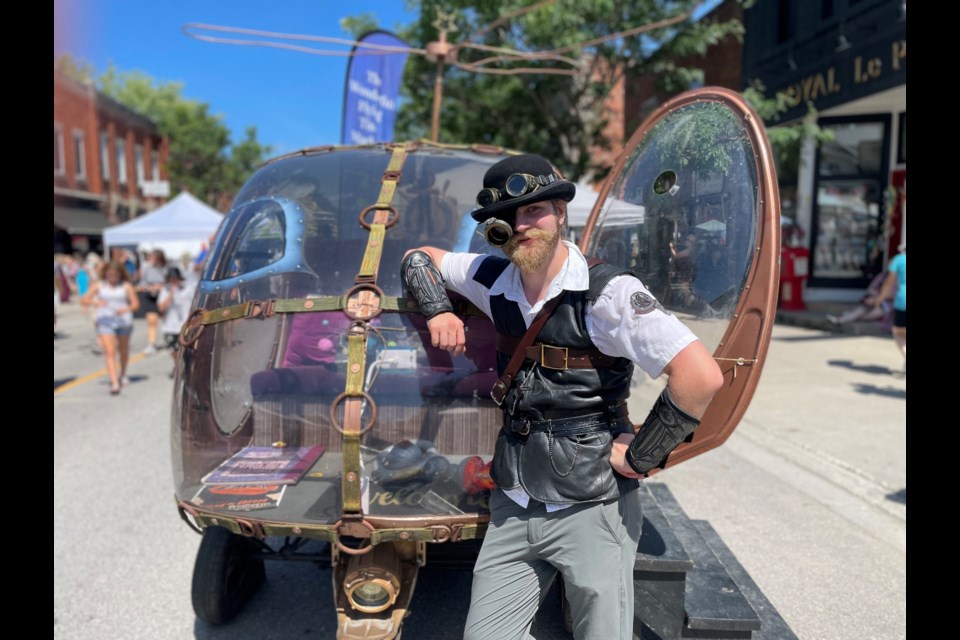 A man who goes by the name Zelius Bobetanan Fischenagan is shown at the Coldwater Steampunk Festival on Saturday with a 'time machine' made by a craftsman in Quebec.