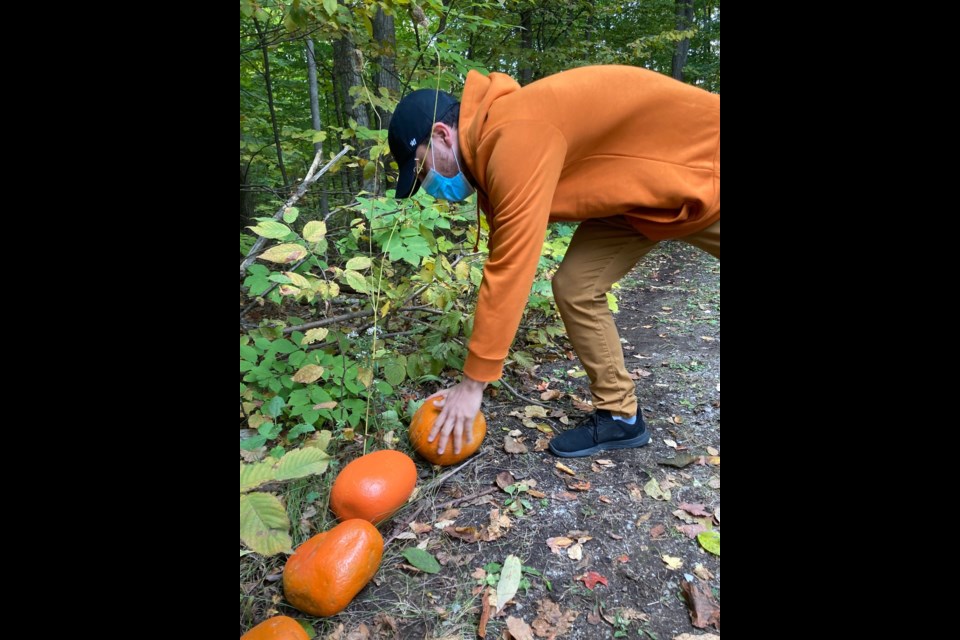 Roberto (Robbie) Garcia, a student at Georgian College’s Orillia campus, places an orange rock on the newly named Truth and Reconciliation Trail.