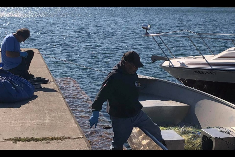 Christian Island commercial fisherman, Ed Williams, left, and Rick Monague are shown doing maintenance on their gill nets.