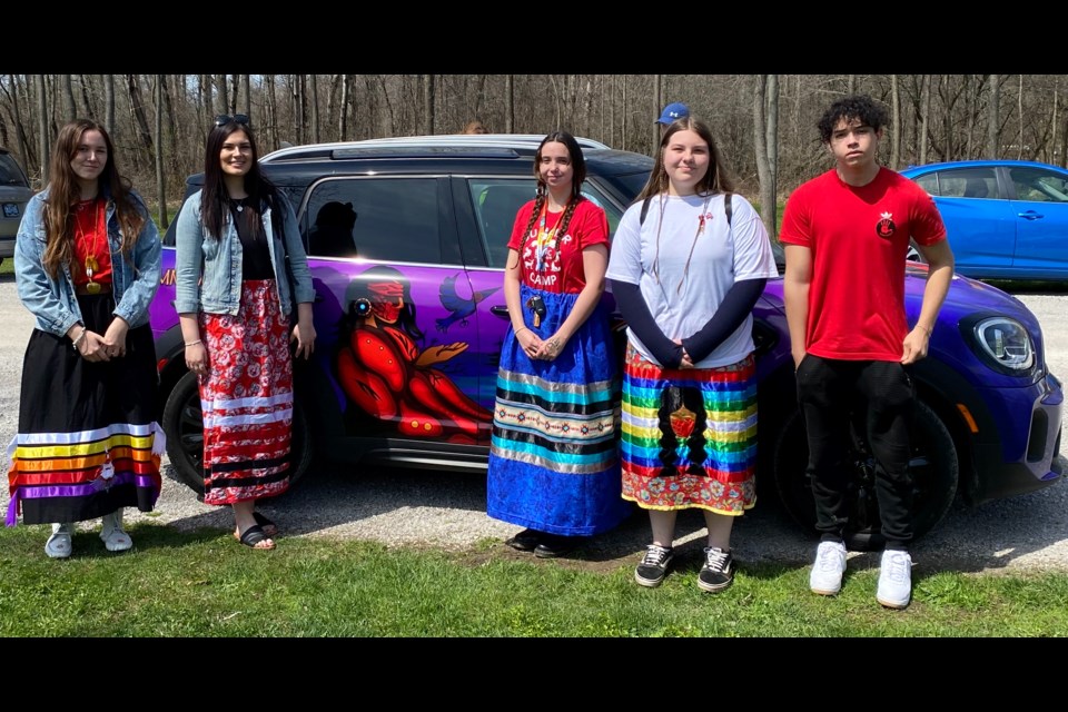 From left: Aniston Deleary, Kallista Jacobs, Mya McGee, Charlotte Snake and Jaden Snache are pictured in front of the Rama Police Service community car on the National Day of Awareness for Missing and Murdered Indigenous Women and Girls and Two-Spirit People, also known as Red Dress Day.