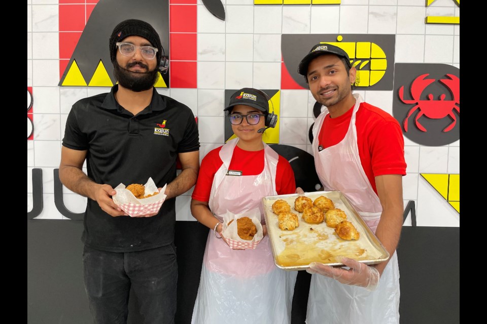 From left are Kajun Chicken & Seafood employees Ekam Singh, Gurpreet Kaur, and Manu Shrivastava who invite you to try their new restaurant on Atherley Road. 