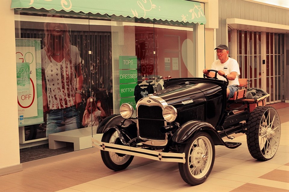 Orillia Heritage Centre volunteer John Smith drives the 1930s Autotrac down the central aisle at Orillia Square Mall on its way to a special new display. Contributed photo