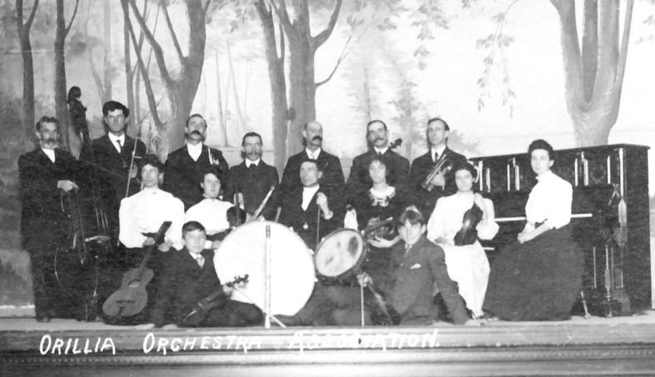 This photo postcard showing 15 members of the Orillia Orchestra Association on the stage of the Orillia Opera House was mailed Jan. 13th, 1909 to Miss Loella Horn, Coaticook, Quebec.