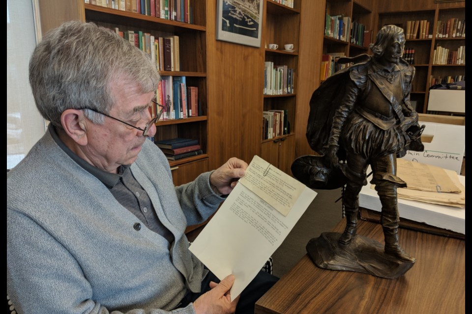 Orillia historian Marcel Rousseau looks at a document about the creation of the Champlain Monument. A bronze model of the statue of Champlain, owned by the library, is in the History Room along with a treasure trove of documents about the evolution of the monument. Dave Dawson/OrilliaMatters
