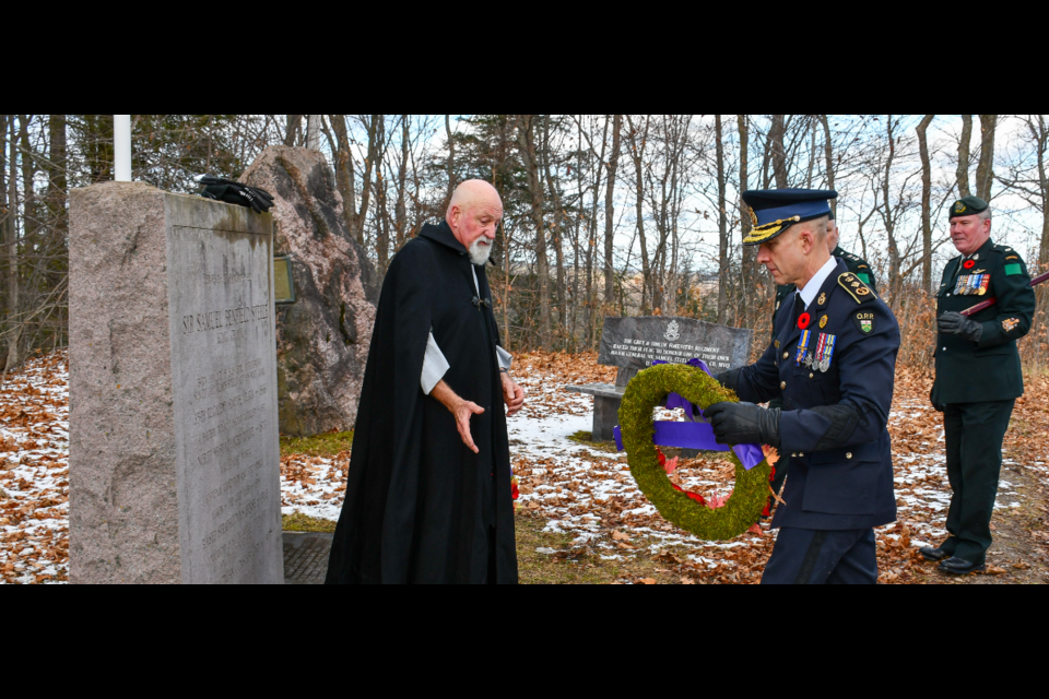 Commissioner Thomas Carrique of the OPP hands a wreath to Rev. Phil Morley at the St. George Anglican Church Remembrance Day Ceremony.