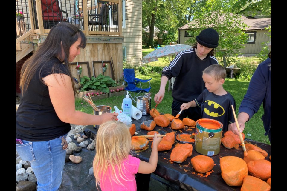 Mandy Noble paints rocks with her kids, Brielle, Brett (wearing hat) and Cody.