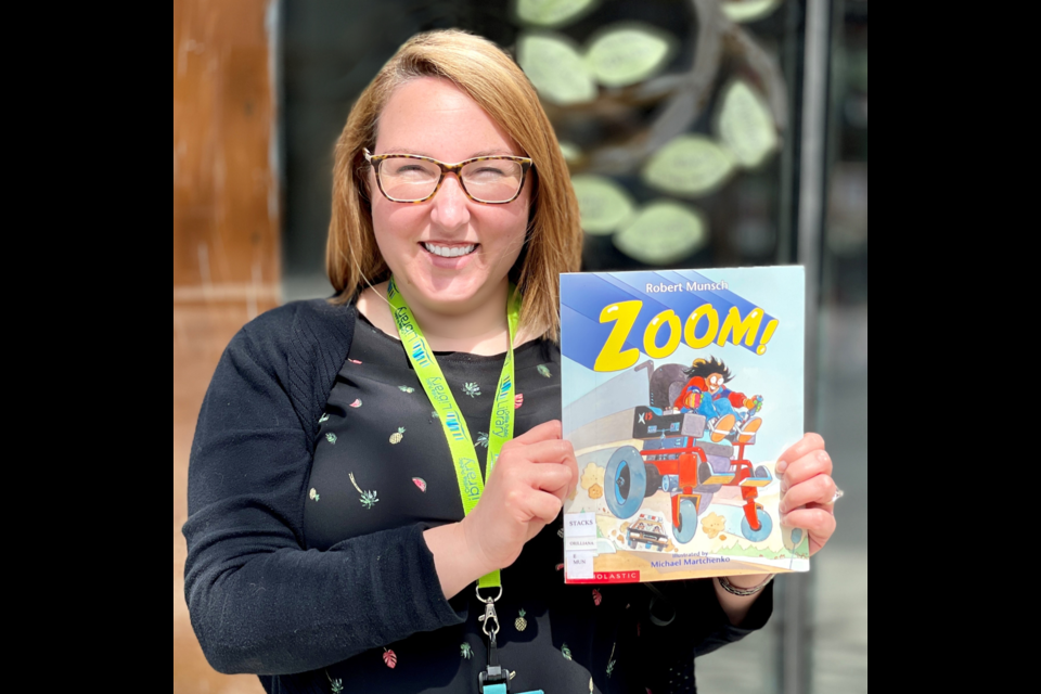 Meagan Wilkinson, director of children and youth services at the Orillia Public Library, is shown with a copy of Robert Munsch's book, Zoom!