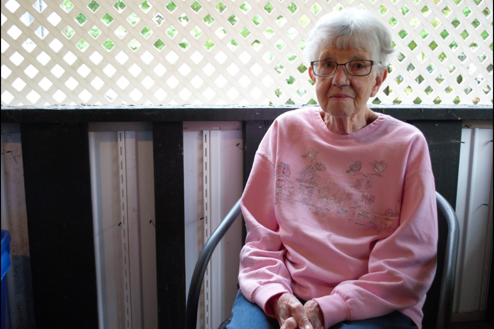 Evelyn Renton sits in her covered porch at Fergushill Estates, upset with the screws that line the walls from newly installed exterior vinyl siding. Jessica Owen/OrilliaMatters