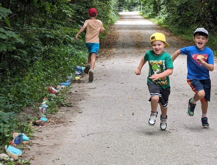 Brothers Bishop and Hendrix Black race down the length of Ricky the Rock Snake, while older brother Ryker runs in the opposite direction. The boys' mom had the idea to paint rocks and place them along the rail trail; there are now more than 200 rocks on the side of the trail in north Orillia.