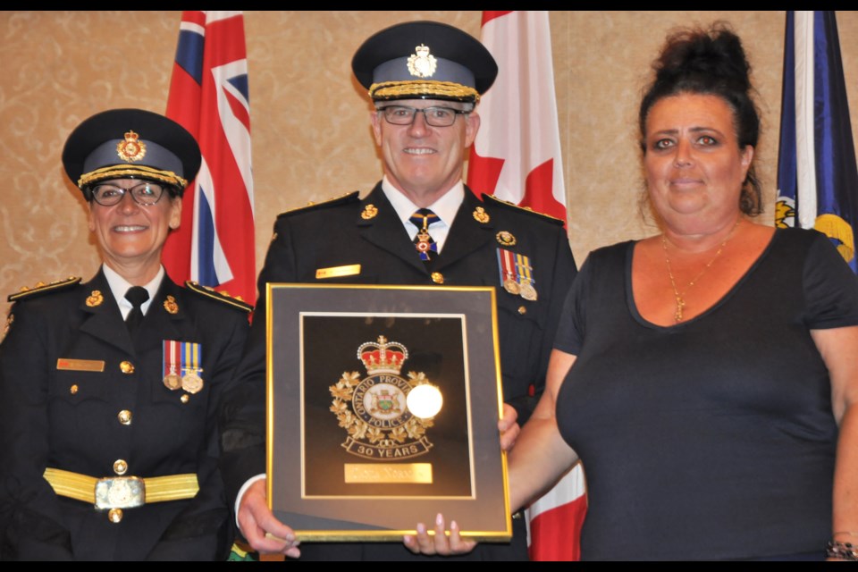 OPP Chief Superintendent Rose DiMarco, left, and Commissioner Vince Hawkes present a 30-year service plaque to Barrie OPP employee Tania Norman, who was also honoured for her community service work. Andrew Philips for OrilliaMatters