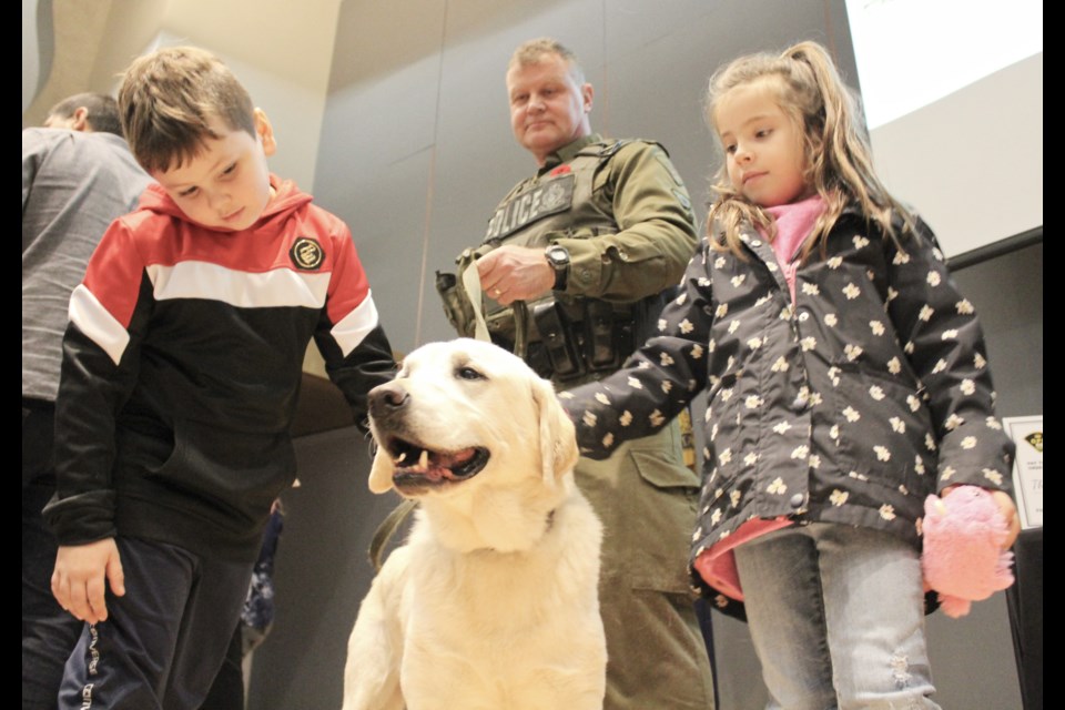 Students from Mnjikaning Kendaaswin Elementary School hang out with retired police dog Dexter while Sgt. Murray Deruiter looks on during an event Monday at OPP General Headquarters in Orillia. Nathan Taylor/OrilliaMatters