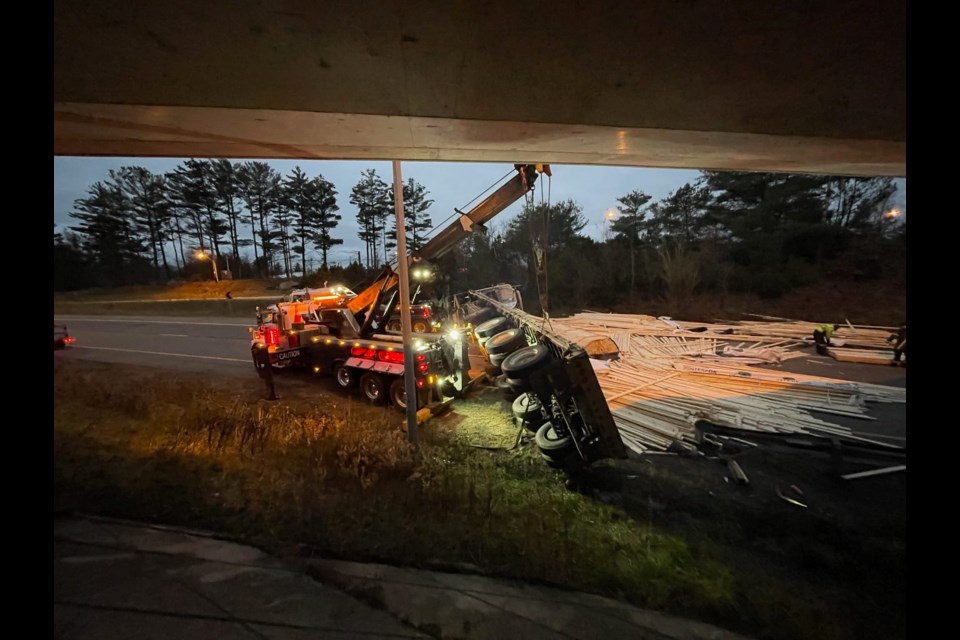 Crews continue to work to clean up lumber and debris after a transport truck rolled on its side on Highway 11 in Gravenhurst Tuesday evening.