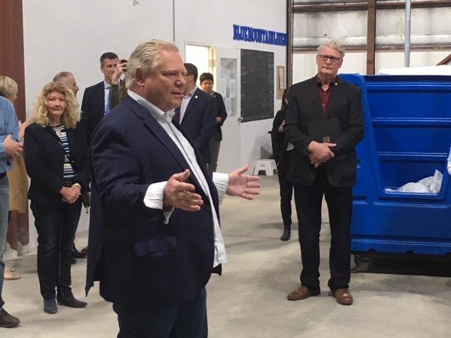 Premier Doug Ford speaks Friday, May 17, 2019, at Blue Mountain Linen in Orillia while Mayor Steve Clarke, right, looks on. Supplied photo