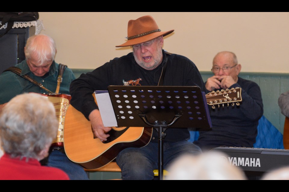 Gerry Shelswell, organizer of the popular event in Rugby, plays lead guitar for the band at a packed community hall. 
