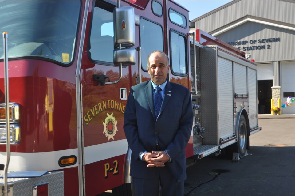 Severn Township Mayor Mike Burkett stands beside one of the municipality’s fire trucks during the official opening of station #2 Saturday morning. Andrew Philips/OrilliaMatters