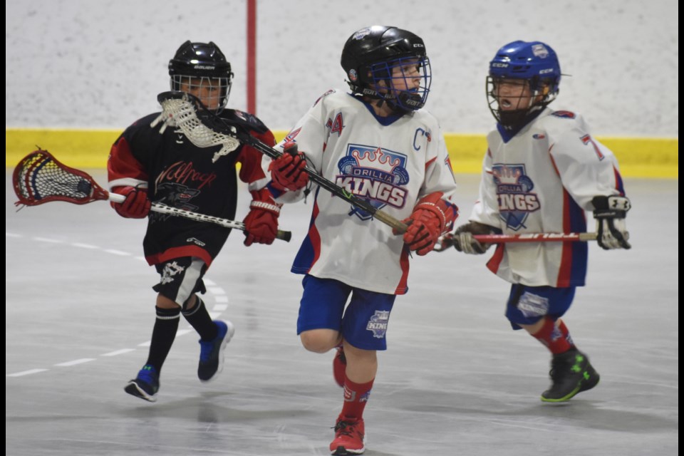 The Orillia Moonstone Mechanical tyke team captain cradles the ball and looks for a teammate to pass to during first period action Saturday morning at the Oro-Medonte Arena in Guthrie. The Innisfil Wolfpack struck first, but Orillia rallied as the two teams battled to a 1-1 draw on Day 2 of the Boyd Balkwill Memorial Lacrosse Tournament. Dave Dawson/OrilliaMatters
