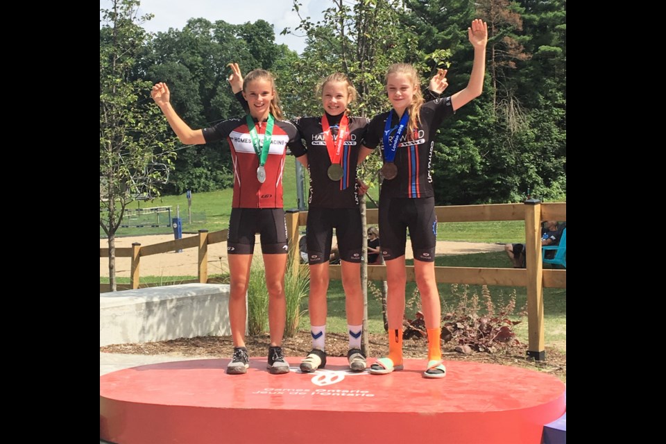 Ava Holmgren, centre, won first place and Isabella Holmgren, right, cycled to a third-place finish in the mountain bike cross country event at the Ontario Summer Games. Contributed photo