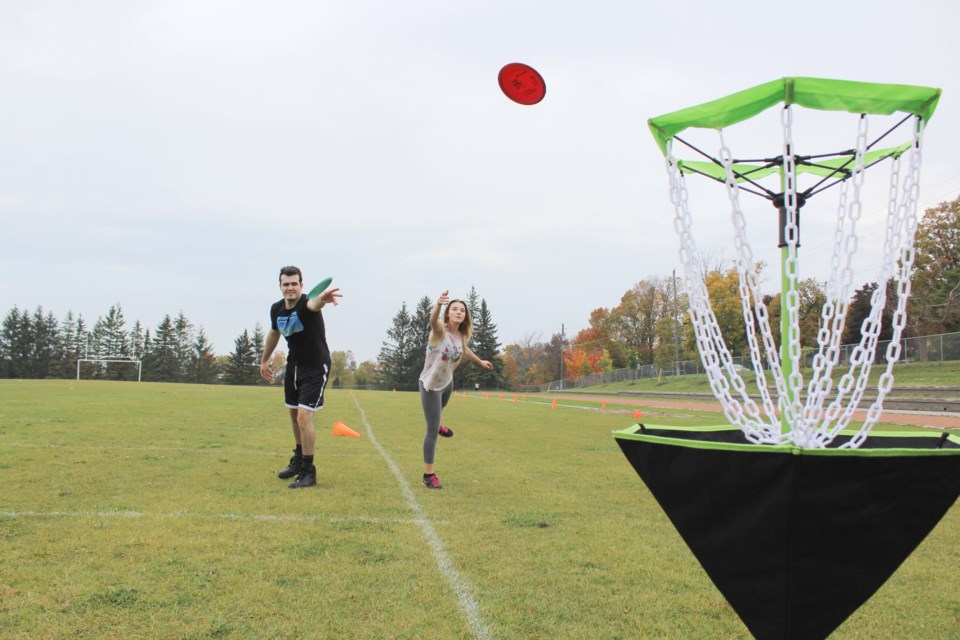 Ryan Heim and Haley Sedore try their hand at disc golf Tuesday during Try Day at Orillia Secondary School. Nathan Taylor/OrilliaMatters