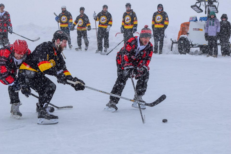 Players battle for the puck at the Taylor Cup to Conquer Cancer pond hockey tournament Saturday. 
