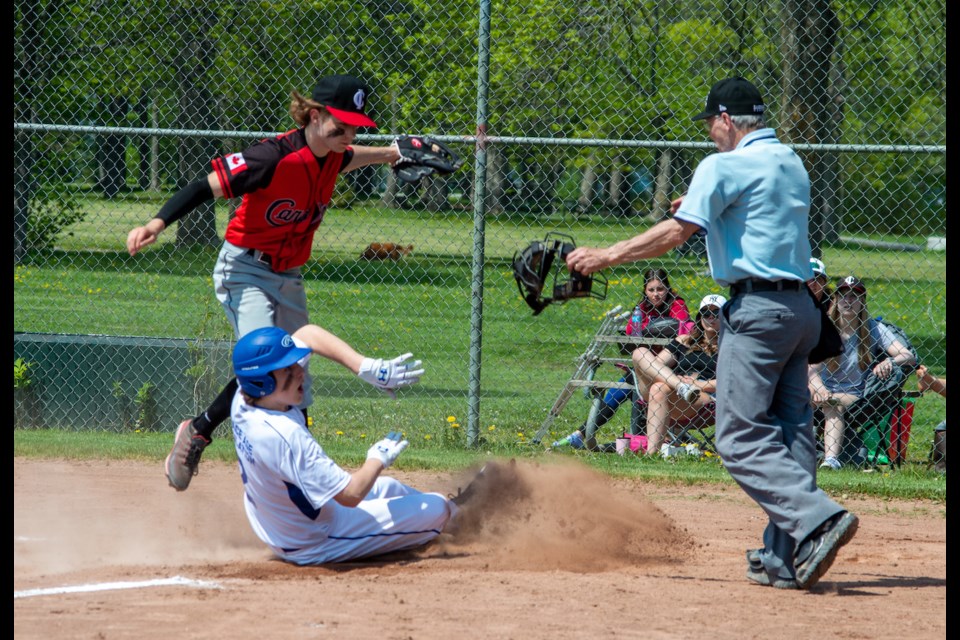 Orillia Royals hitter James Pritchard is safe after sliding under a tag during a play at the plate.