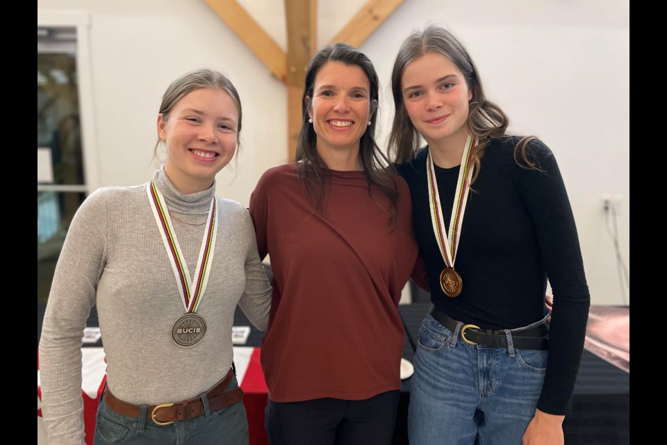 Ava Holmgren, left, and her twin sister Isabella, right, are shown with their mom, Lisa. The twin sisters celebrated their recent World Cyclocross Championship success at Hardwood Ski and Bike on Wednesday night. 