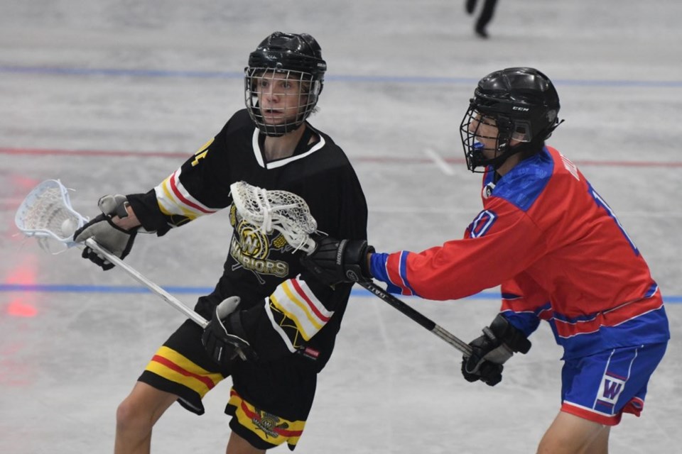 A Whitby Warriors player tries to get past a defender on the way to the net at the Boyd Balkwill Memorial Lacrosse Tournament Sunday.