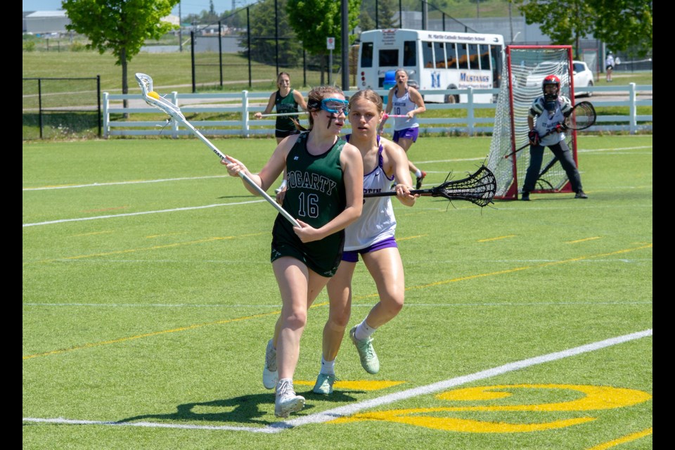 Patrick Fogarty midfielder Hayley Ball protects the ball from a St. Martin Secondary School defender during the Trillium Cup girls' lacrosse tournament on Tuesday afternoon. 