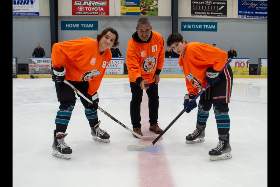 Spencer Shropshire, left, and Johnny Norris, right, of the U15A Orillia Terriers met at centre ice for a ceremonial puck drop before the Orange Jersey Project game on Friday night. The puck was dropped by Gary Maracle who is the Director of Representative for the Orillia Minor Hockey Association. 