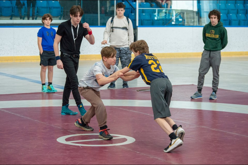 Ardagh Bluffs Public School's Tate DeVroom, left, is pushed by Shanty Bay Public School's Ben Ruttan, right, during the Simcoe County Elementary School Wrestling Championships on Thursday morning. 