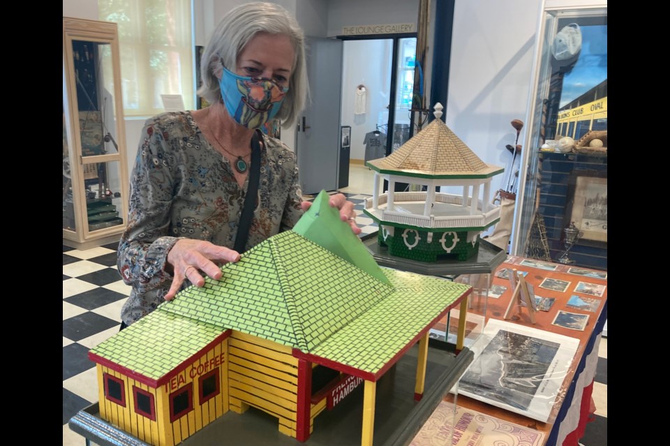 Sheila Davis, an Orillia Museum of Art and History volunteer, examines a model of Frenchs, a waterfront landmark. Davis and volunteer Bruce Jones have put together Summer in Orillia, an exhibit that will continue through September. Sam Gillett/OrilliaMatters