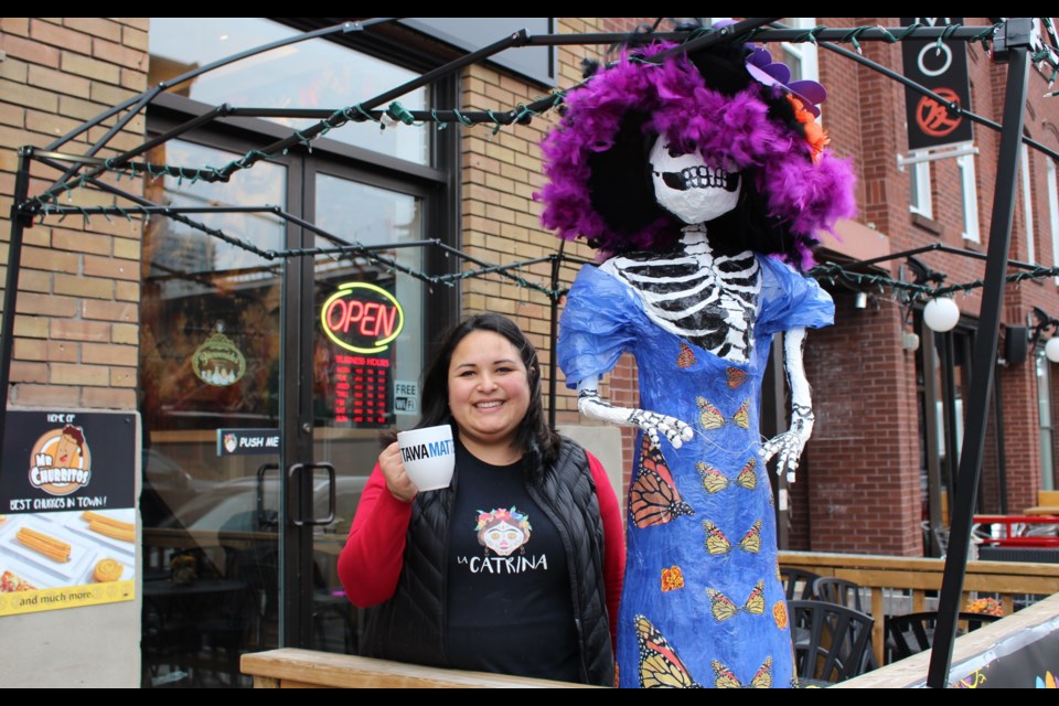 Co-owner Diana Martinez-Ortega stands next to "La Catrina", the namesake of her and her husband's new café in the ByWard Market. Drew May/OttawaMatters.com