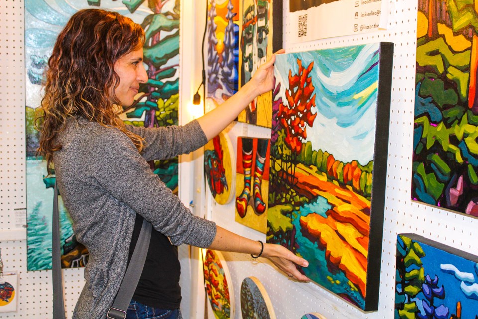 Lisa Leskien, an artist from Sydenham, Ont., near Kingston made sure one of her paintings, Hemlock Trail Hike, was hung just right at the Pelham Art Festival Sunday at the Meridian Community Centre.