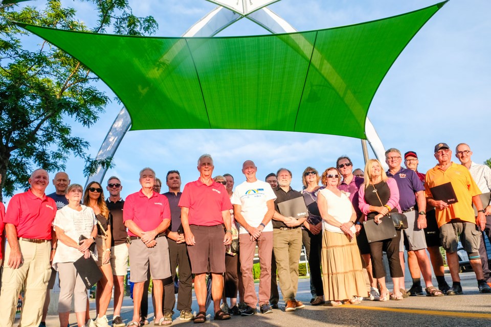 Pelham Deputy Mayor, John Wink (red shirt, black shorts) and Frank Adamson (white shirt) are flanked by members of the business community who donated to help resurrect the Pelham Town Square Arches.