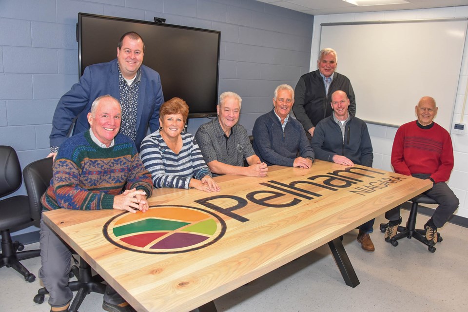 Pelham Councillors Kevin Ker, Shellee Niznik, Brian Eckhardt, John Wink, Wayne Olson, and Bob Hildebrandt, with CAO David Cribbs, and Manager of Public Works Ryan Cook, seated at the new meeting room table created by Public Works staff, emblazoned with the Pelham logo.