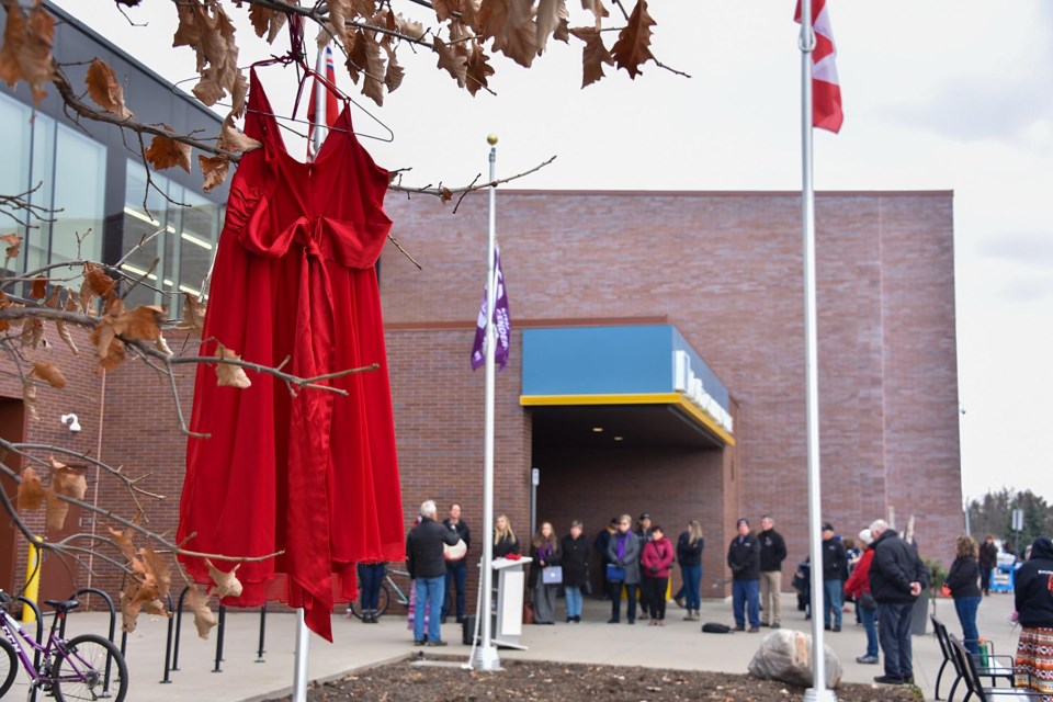 Red dresses hang in the trees outside the MCC, symbolizing missing and murdered Indigenous women and girls across Canada.