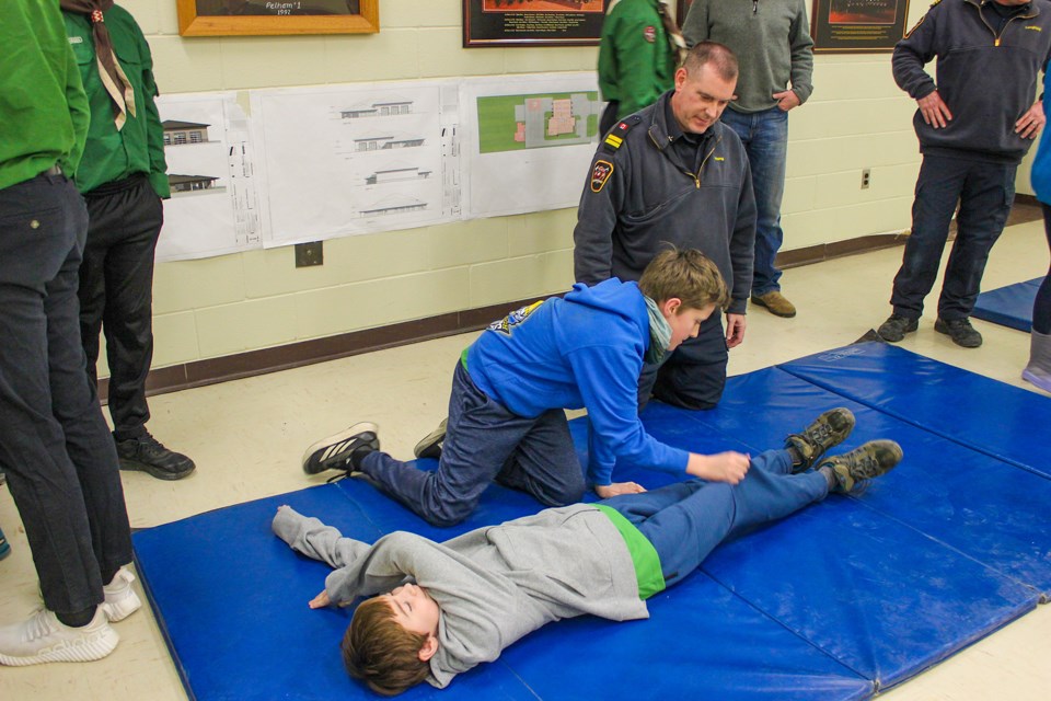 Pelham Fire Department Training Officer Greg Young watches on as scout Jonah Moore helps Linden McLaren into the recovery position. The 3rd Fonthill Scouting Group recently visited the fire hall on Highway 20 to learn about first aid and fire safety.