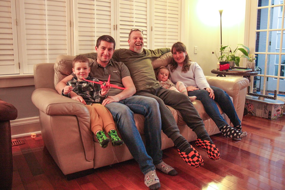 Steve Stadnyk (centre) relaxes at home with the Bap family from Ukraine, including Roman, Mariana, their daughter Mia, and son Mark.