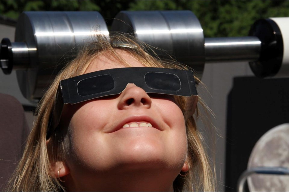Girl checks out eclipse in image that was part of resident's presentation to council