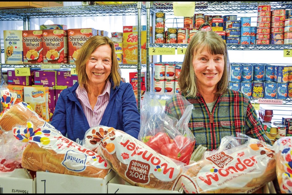 Pelham Cares volunteers Debbie Harrison and Wendy Glaab stock shelves at the food bank in this file photo.  DON RICKERS