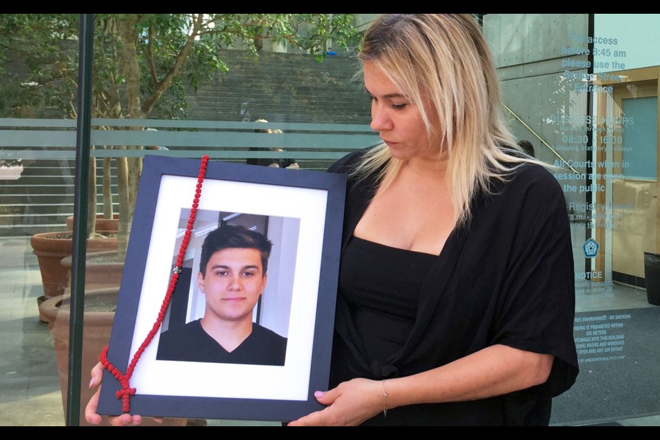 Clara Gordic holds a photo of her slain son Luka outside of B.C. Supreme Court in Vancouver during a hearing held in 2018. BURNABY NOW FILES
