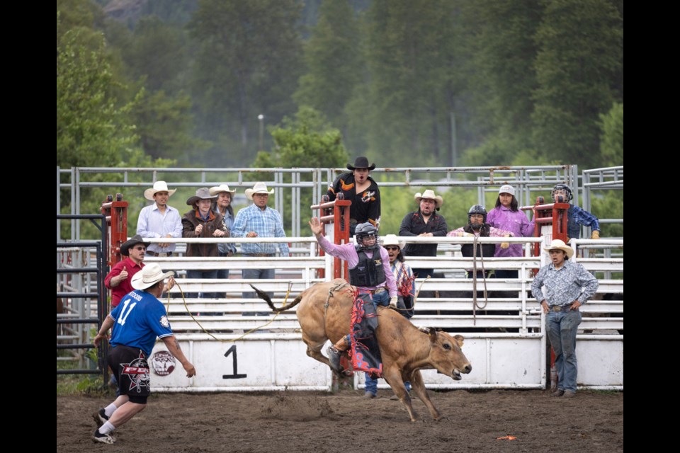 STEER CLEAR A bull rider hangs on while competing at the Lil’wat Nation’s Lillooet Lake Rodeo on Sunday afternoon, May 21. The event drew massive crowds to Mount Currie from May 20 to 22 this year. 