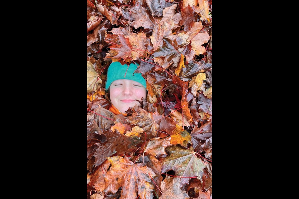WINTER IN AUTUMN Eleven-year-old Ella Winter enjoys the fall leaves near her house in Rainbow last week. 