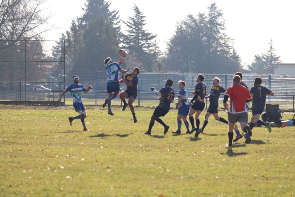 Axemen Rugby Club members (in blue, green and white) take on Scribes RFC in a Division 2 match in 2023. 